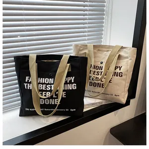 Detail of canvas tote bags with front snap pocket and reinforced woven handles