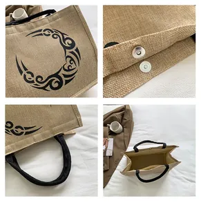 Detalle del bolso grande de lona con hebilla metálica magnética y asas de tela negras