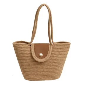 Sac seau tissé tendance avec rabat en cuir et boucle en perle sur fond blanc immaculé