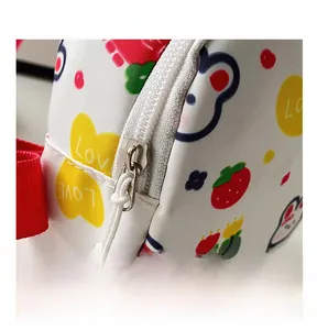 Detail eines weißen Reißverschlusses und roten Gurtes an der Kindertasche