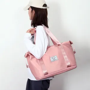 Pink large capacity waterproof travel bag with shoe compartment shown on shoulder