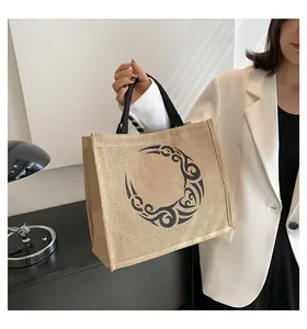 Detalle del bolso de yute con diseño de tótem de luna negra y asas de tela fuertes