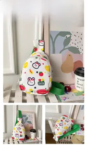 Detail der weißen Kinder-Brusttasche mit Hasen-Prints und grünem Nylon-Schultergurt