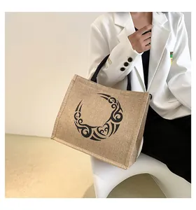Detalle del bolso tote de yute con estampado tribal de luna y corazón y asas tejidas