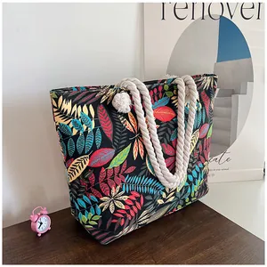 Dettaglio della grande borsa tote in tela con stampa di foglie e manici in corda di cotone