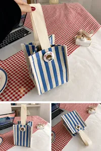 Detail view of mini canvas tote bag with blue vertical stripes and cartoon badge design