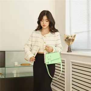Vintage mintgroene leren handtas met grote gesp gecombineerd met een tweed jasje