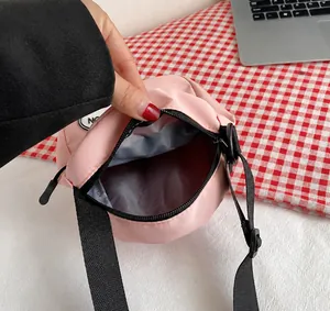 Vista interior del bolso bandolera rosa mostrando capacidad para el móvil y accesorios