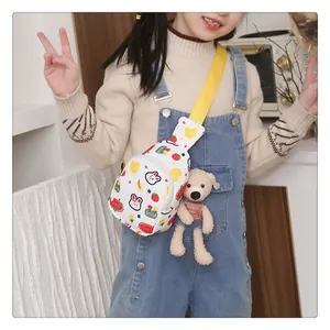 Detail der weißen Kinder-Brusttasche mit Hasen-Print und braunem Bärenanhänger