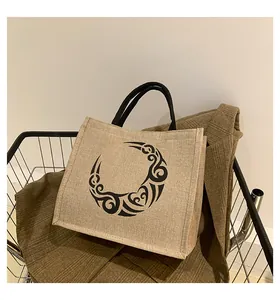 Detalle de bolso tote de yute natural con estampado tribal negro y asas de cuerda