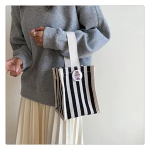 Detail view of mini striped canvas tote bag with round badge and off-white handles