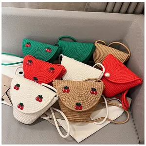 Détail de sacs en paille tissée colorés montrant la texture et la broderie