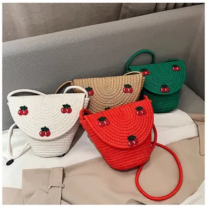 Détails de la texture tissée en coton avec broderie cerise sur les sacs bandoulière