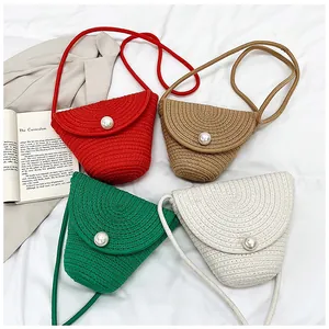 Détail de sacs à bandoulière en paille tressée avec fermoirs perles en quatre coloris d'été