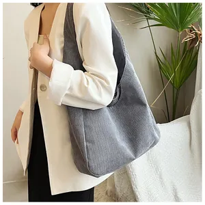 Seitenansicht der grauen Cord-Einkaufstasche mit Streifentextur und breitem Gurt