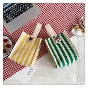 Top view of striped canvas storage bags with cute cartoon pins on checkered background