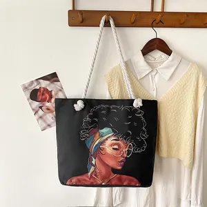 Borsa tote in tela nera con ritratto d'arte africana e manici in corda bianca appesa