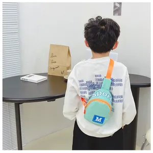Detailansicht der mintgrün-orangen Kinder-Sport-Brusttasche getragen von einem Kind