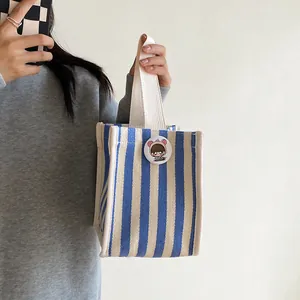 Blue and white striped canvas handbag with cream woven handles and a cute girl badge