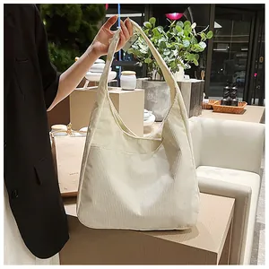 Detail der cremefarbenen Cord-Schultertasche mit weicher Rippstruktur und großem Hobo-Design