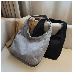Detailierte Textur grauer und schwarzer Cord-Hobo-Taschen auf weichem Stoffsofa