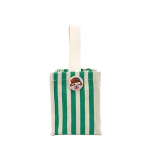 Mini canvas tote bag with green and white stripes and a cute cartoon badge for storage
