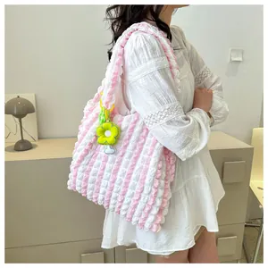 Detail of pink and white striped bubble texture tote bag with yellow flower charm accessory