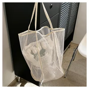 Sac fourre-tout en maille blanche semi-transparente avec un bouquet de tulipes frais