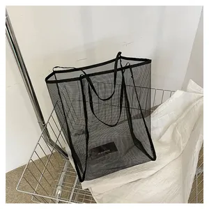 Détail d'un sac cabas en filet noir montrant la texture translucide dans un panier
