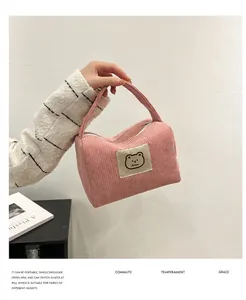 Dettaglio della trama in velluto a coste rosa e della toppa con orsetto sulla pochette