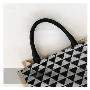 Close-up of circular black woven handles and geometric textured fabric on a tote bag