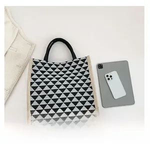 Flat lay of geometric tote bag with black and white triangles and beige linen trim