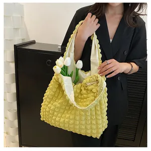 Macro view of yellow bubble textured tote bag fabric and soft pleated canvas material