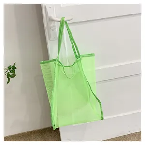 Détail d'un sac de plage en maille vert fluo avec trous respirants suspendu à une porte