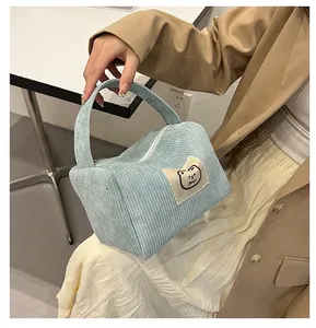 Dettaglio della borsa da toilette in velluto a coste azzurro con patch di gatto
