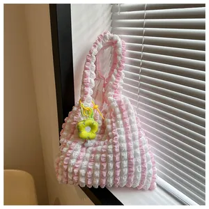 Detail of pink seersucker striped shoulder bag with a yellow daisy floral charm