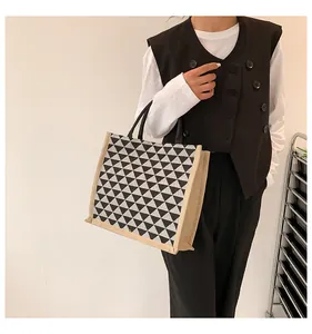 Detailed view of linen tote bag featuring black and white geometric triangle pattern prints