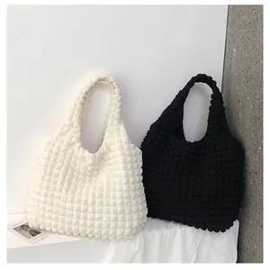 Detail of 3D bubble textured tote bags in black and beige with pleated canvas fabric