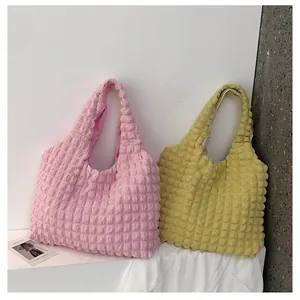Detail of pink and yellow textured bubble tote bags with 3D pleated fabric texture