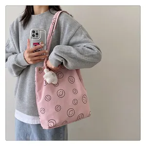 Pink corduroy tote bag with smile patterns and a cute white plush bear charm detail