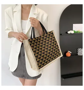 Detail view of the geometric triangle pattern and sturdy linen sides of this tote bag