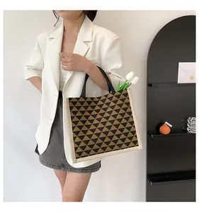Detail of canvas tote with black triangle pattern and contrast cream stitched trim edge