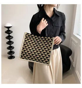 Linen tote bag featuring black and yellow geometric triangles with dual handles