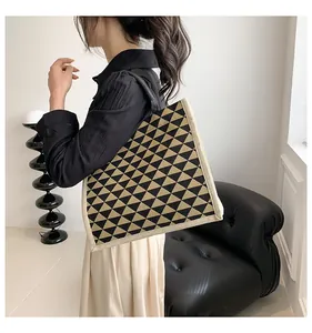Close-up of geometric pattern linen tote bag carried by a model in modern interior