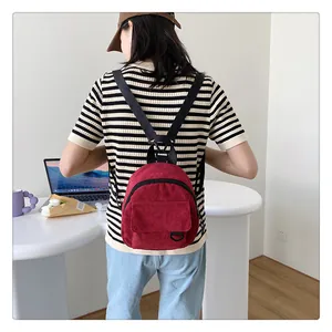Détail du mini sac à dos en velours côtelé bordeaux porté avec des bretelles réglables