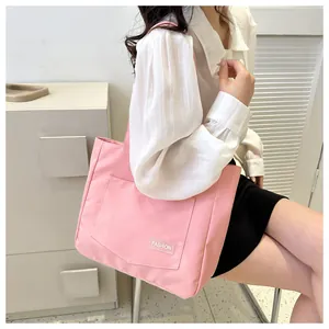 Close-up of pink canvas tote bag with FASHION label and spacious front pocket