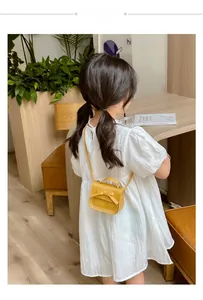 Girl wearing a mini yellow crossbody bag with a bow decoration on a white dress