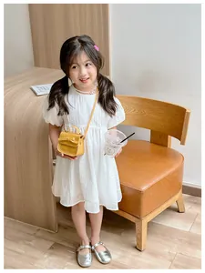 Girl in white puff sleeve dress with a bright yellow bow crossbody bag and Mary Janes