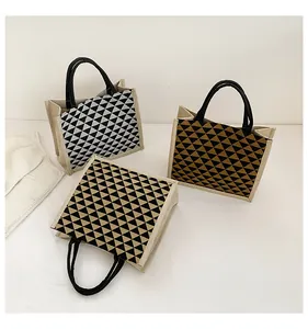 Detailed view of linen tote bags with geometric triangle patterns and round handles