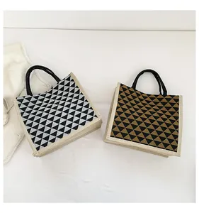 Detail of linen tote bags with geometric triangle prints and black circular handles